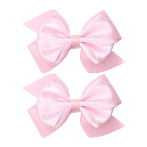 Detail view of pink grosgrain ribbon hair bows with dual-layer fabric and polished texture