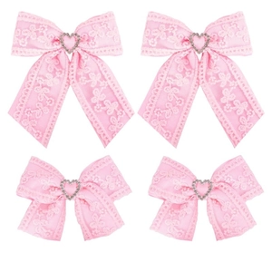 Detail view of pink ribbed lace hair bows with sparkling heart-shaped crystal centers