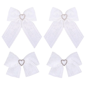 Close-up of four white lace hair bows featuring sparkling heart-shaped rhinestones