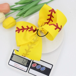 Yellow baseball print ribbon bow hair tie on electronic scale weighing twelve grams