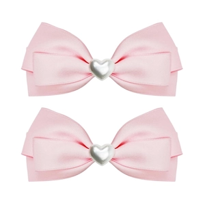 Close-up of pink satin ribbon hair clips featuring a metallic heart-shaped center decoration