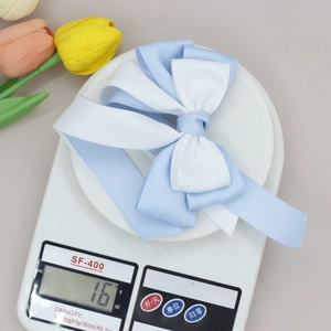 Detailed view of the 16g weight measurement for the blue and white bow hair clip