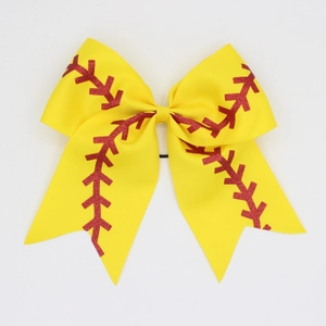 Macro shot of yellow softball cheer bow with red glitter stitching and black hair tie