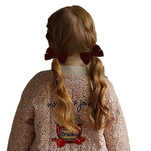 Set di fermagli per capelli con fiocchi di velluto bordeaux su una bambina