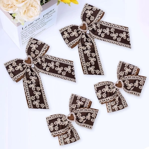 Detail view of 4-piece set featuring ribbon lace bows with heart rhinestones and embroidery