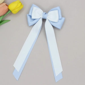 Close-up of blue and white layered ribbon bow hair clip with elegant long streamers