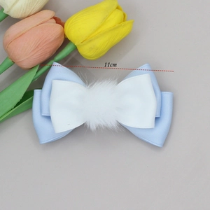 Detail view of 11cm blue and white bow hair clip with a fluffy pom pom center