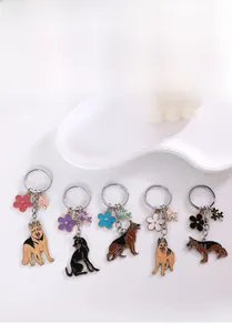 Detail of colorful enamel German Shepherd metal keychains with decorative floral pendants