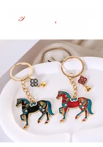 Close-up of enamel horse keychains in red and black with traditional floral patterns