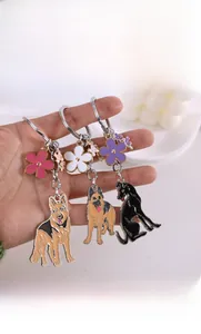 Detailed close-up of metal enamel German Shepherd dog keychains with colorful flower charms