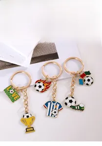 Detailaufnahme goldener Fußball-Schlüsselanhänger mit Pokal- und Fußball-Emaille-Anhängern