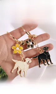 Detailed view of golden retriever alloy keychains with enamel flowers and pearl accents