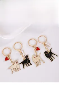 Vue détaillée des porte-clés Labrador en métal noir et beige avec pendentifs
