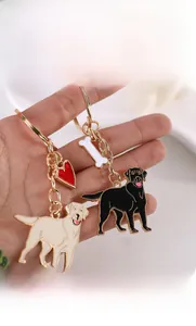 Détail de porte-clés chien Labrador avec breloques cœur et os en émail sur crochets dorés