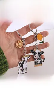 Détail des porte-clés émaillés vache de dessin animé avec breloques marguerite et tournesol