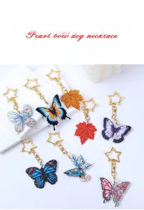 Detailed macro view of acrylic butterfly and glittery maple leaf charms with star-shaped clasp