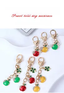 Detail view of colorful apple-shaped enamel keychains with heart-shaped ring and pearl charms