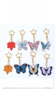 Detail of acrylic butterfly and maple leaf charms with star-shaped gold keychains