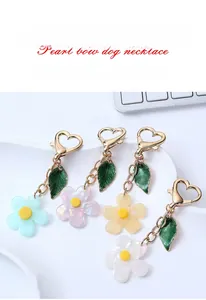 Dettaglio set portachiavi a fiore in acrilico con petali opachi e clip a cuore oro