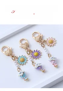 Vue détaillée des porte-clés marguerite en bleu, violet et rose avec mousqueton en cœur