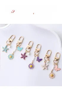 Close-up of alloy butterfly and starfish keychains with enamel and faux pearls