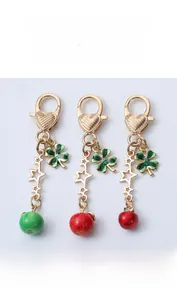 Detailed close-up of a 3D apple keychain with clover and heart charms in gold finish