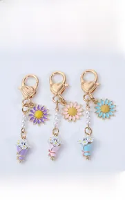 Détails des pendentifs marguerites colorés avec chaînes de perles et fermoirs en cœur