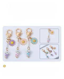 Macro detail of enamel daisy flower charms and pearl chains for colorful keychains