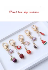 Detail view of alloy fruit keychains with strawberry and watermelon enamel pendants