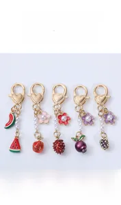 Detailed set of cute fruit keychains with strawberries and grapes on gold lobster clasps