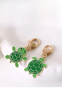 Vue détaillée de porte-clés tortue en émail vert avec fermoir cœur doré
