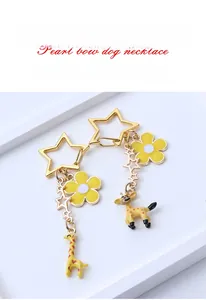 Detailed view of the gold-plated cartoon giraffe keychain with flower and star charms