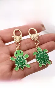 Détail du porte-clés tortue en émail vert avec fermoir mousqueton cœur doré et carapace