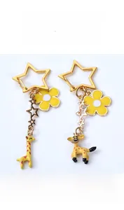 Detailed view of yellow giraffe keychain with golden star hook and flower charm decoration