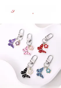 Detail view of butterfly keychains with colorful polka dots and pearl flower charms