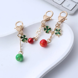 Three-piece set of gold apple keychains with clover pendants and colorful beads