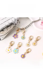 Detailed macro view of daisy alloy keychains with heart-shaped golden metal clasps