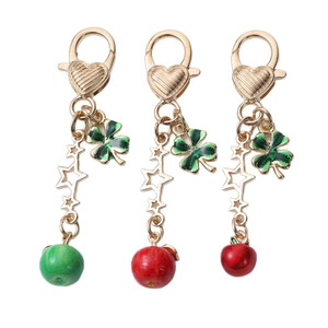 Golden clover and apple keychain pendants with heart-shaped clasps in red and green