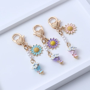 Trois porte-clés marguerite colorés avec fermoir cœur et perles pour décor de sac