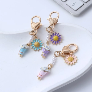 Lot de trois porte-clés marguerite avec fermoir coeur et perles aux tons pastels