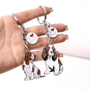 Cute metal beagle dog keychains with I Heart Dogs tag held in hand on white background