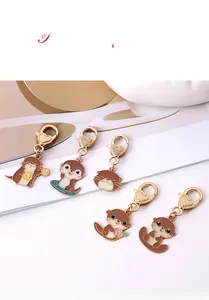 Détail de cinq porte-clés loutre mignons en métal avec fermoirs dorés en forme de cœur