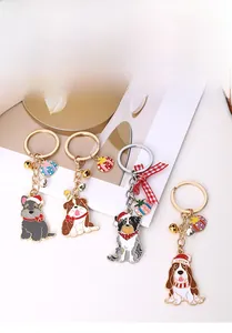 Close-up of metal Christmas dog keychains with festive hats and bells in four breeds