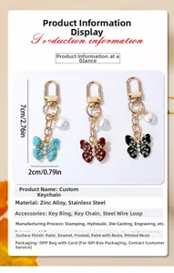 Détail de porte-clés papillon en perles en trois couleurs avec fermoir et charme de coeur