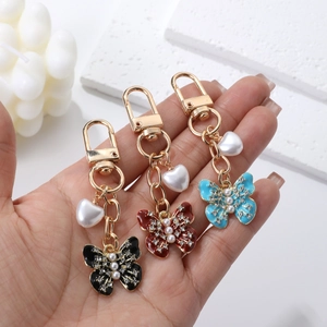 Charmants pendentifs papillon avec perles pour sacs et clés en noir, rouge et bleu