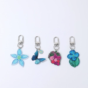 Set of four acrylic floral and butterfly keychains with silver metal D-ring clasps