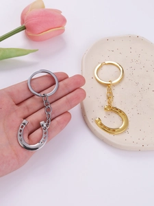 Detailed close-up of lucky horseshoe metal keychains in gold and silver plating
