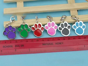 Detailed view of colorful paw-shaped pet tags with metal lobster clasps in various colors