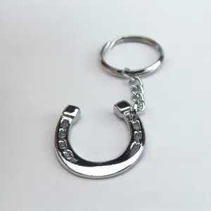 Close-up of polished silver horseshoe keychain with metallic ring and link chain detail