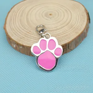 Zinc alloy pet tag with pink paw print charm on rustic wood with a lobster clasp